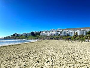 een zandstrand met appartementen op de achtergrond bij Puerto Velero Primera Línea Primer Piso al lado de la Playa! 8pax in Puerto Velero