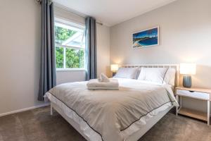 une chambre avec un grand lit avec une fenêtre dans l'établissement Ti Cottage - Stay Waiheke, à Oneroa
