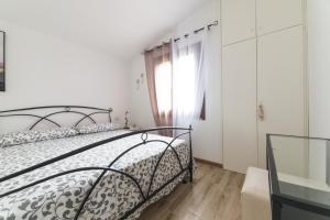 Schlafzimmer mit einem Bett und einem Fenster in der Unterkunft villa aloe 2 in Costa Paradiso