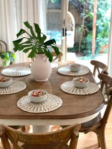 a wooden table with four plates and bowls on it at Byron Marvell in Byron Bay