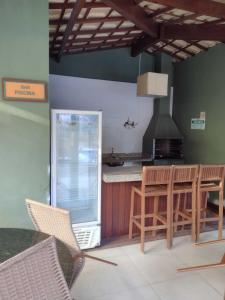 y cocina con mesa, sillas y fogones. en Praia do Forte Kauai Bahia, en Praia do Forte