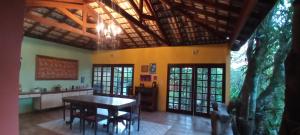 a dining room with a table and a kitchen at Chalé Rancho Aratama in Jacareí
