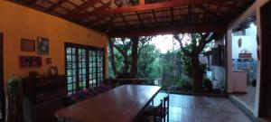 a dining room with a table and a large window at Chalé Rancho Aratama in Jacareí