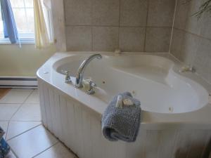 a white bath tub with a faucet in a bathroom at Whispering Waves Cottages in Roseway +34 photos