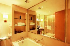 a bathroom with a tub and a large mirror at Jinling Resort Nanjing in Nanjing