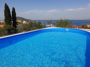 a large blue swimming pool with a view of the ocean at Apartment in Kali with Sea View, Balcony, Air Conditioning, Wi-Fi (4566-6) in Kali +27 photos