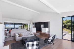 ein Wohnzimmer mit einem Sofa und einem Tisch in der Unterkunft Whakamaria - Leigh Holiday Home in Leigh