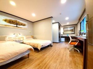 a hotel room with two beds and a desk at Ryu Guest House Gangnam in Seoul