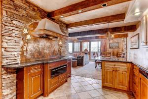 una cocina con armarios de madera y una pared de piedra. en Beaver Run Resort - Peak 9 Penthouse en Breckenridge