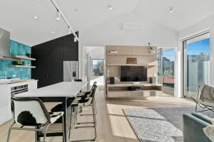 a kitchen with a table and chairs and a tv at Bull Ridge Escape - Wanaka Holiday Home in Wanaka