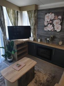 a living room with a flat screen tv and a table at Luxury Latest Model Holiday Home in Blackpool
