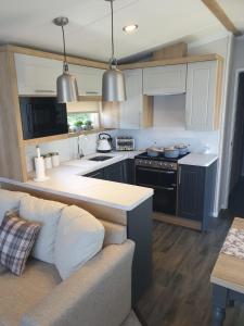 a kitchen with a couch and a stove top oven at Luxury Latest Model Holiday Home in Blackpool