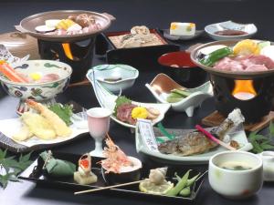 una mesa cubierta con muchos platos de comida en Hotel Omodaka, en Yamanouchi
