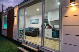 a kitchen and a living room with a sliding glass door at Tiny House in Belconnen 1BR Self Contained Wine in Higgins