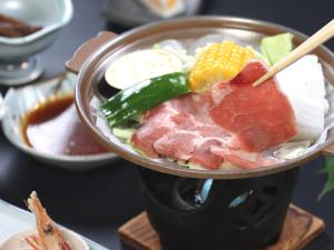 a cup of food with meat and vegetables on a table at Hotel Omodaka in Yamanouchi