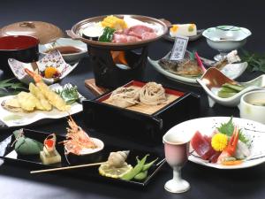 una mesa con muchos tipos diferentes de comida en ella en Hotel Omodaka en Yamanouchi