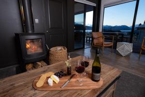 Habitación con mesa con copas de vino y chimenea en Tekapo Lake House en Lake Tekapo