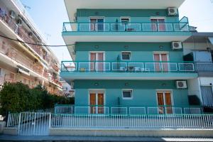 a blue building with a balcony on the side of it at Amelies Apartments in Paralia Katerinis