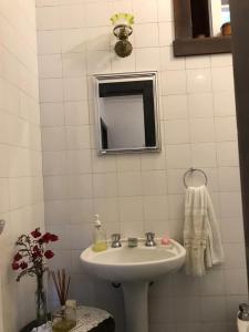 uma casa de banho branca com um lavatório e um espelho em Fachoalto Budget em Petrópolis