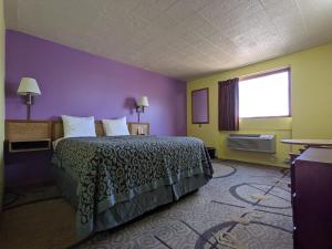 a hotel room with a bed and a window at Great Plains Budget Inn in Lincoln