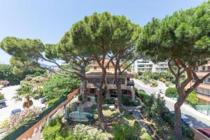 vistas a un edificio con árboles en el primer plano en Hôtel Les Alizés, en Cavalaire-sur-Mer