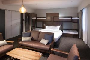 um quarto de hotel com uma cama e beliches em ALPHABED INN 小樽駅前 em Kita-hamachō