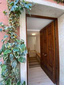 a door leading into a hallway with a plant at Casa Vacanze Giorgetta Palazzina privata di due piani in Chioggia