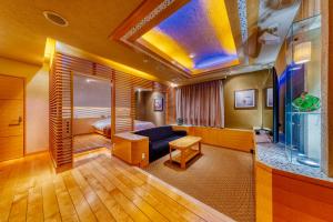 Habitación de hotel con cama y sala de estar. en Hotel Lotus Chiba -Adult Only, en Niikura