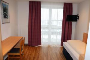 a room with a desk and a bed and a window at Hotel Wahlmüller in Sattledt