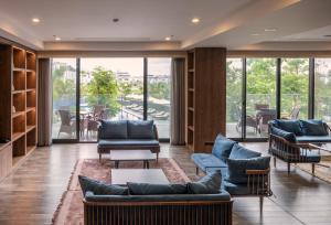 a lobby with couches and chairs and a large window at Roygent Parks Hai Phong in Hai Phong