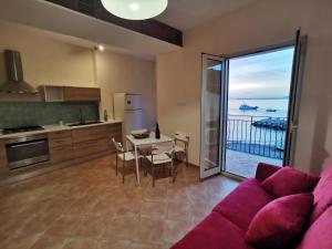 a living room with a couch and a table and a kitchen at Brezza Marina in Massa Lubrense