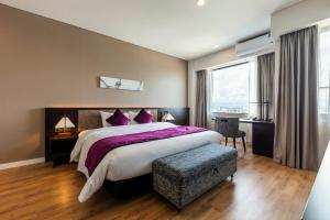 a bedroom with a large bed with purple pillows at Roygent Parks Hai Phong in Hai Phong