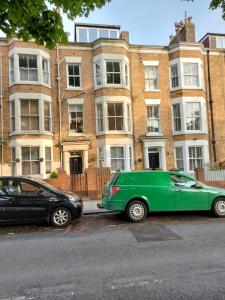 dois carros estacionados em frente a um edifício em Trafalgar Retreat em Scarborough
