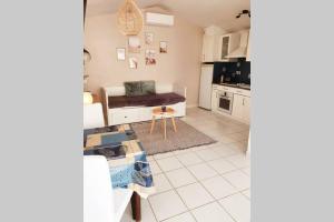 uma sala de estar com um sofá e uma cozinha em Charmant petit studio à 2 pas du village em Plan-de-la-Tour