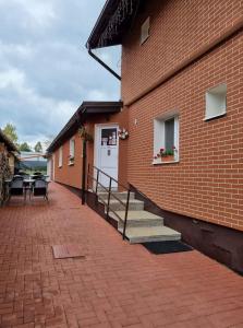 a brick building with stairs leading to a white door at Ubytovanie MI - TATRY in Kravany