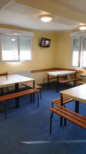 une salle de classe avec des tables et une télévision murale dans l'établissement Hôtel & Résidence Avermes, à Avermes