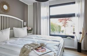 a bedroom with a white bed and a window at Haus Ostsee in Göhren