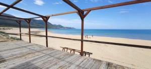 a view of a beach with a wooden boardwalk at Villa Mary in Fluminimaggiore