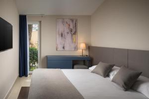 乌马格Istrian Villas Plava Laguna的一间带大床和书桌的卧室