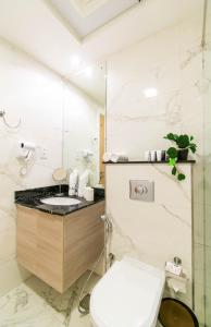 a white bathroom with a toilet and a sink at Stella Stays Beautiful Studio Dubai JVC Large Terrace in Dubai