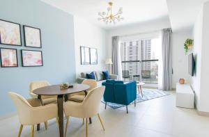 a dining room and living room with a table and chairs at Stella Stays Modern 2 BDR Dubai JVC Private Balcony in Dubai