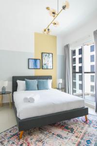 a bedroom with a large bed and a window at Stella Stays Blissful 1 BDR Dubai JVC Private Balcony in Dubai