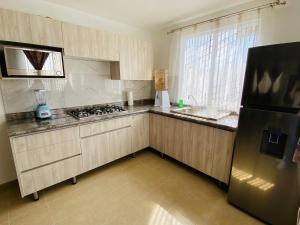 uma cozinha com um frigorífico preto e um lavatório em Casa Turquesa em León