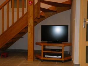 uma televisão sentada numa mesa ao lado de uma escada em Gîte Xonrupt-Longemer, 3 pièces, 4 personnes - FR-1-589-218 em Xonrupt-Longemer
