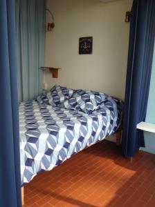uma cama num quarto com cortinas azuis em Bleu Soleil em La Grande-Motte