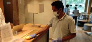 a man wearing a mask and gloves standing at a counter at Holiday Inn Express Hyderabad Banjara Hills, an IHG Hotel in Hyderabad