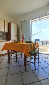 a kitchen with a table and two chairs and a large window at Casa Sunrise - Lovely sea front apartment in Sciacca