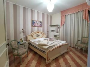 a bedroom with a bed and two chairs at La Casa Di Torre Di Palme in Marina Palmense