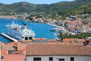 a large boat docked in a harbor with houses at ViSun Apartment 2 in Vis