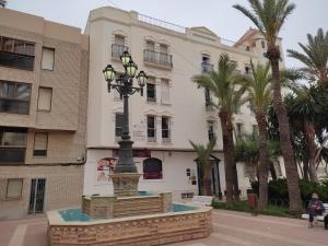 a street light in front of a building with palm trees at garrucha 100 mts playa, 2 Dorm in Garrucha